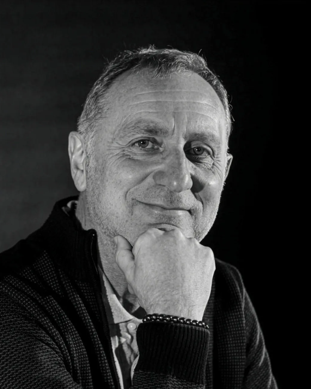 Bruno Laurent, souriant, le menton posé sur la main, en noir et blanc